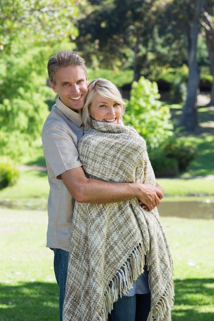 Sonriente pareja abrazándose en el parque