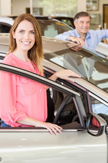 Sonriente pareja apoyándose en el coche