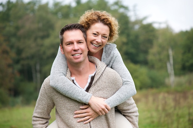 Sonriente pareja divirtiéndose con paseo a cuestas