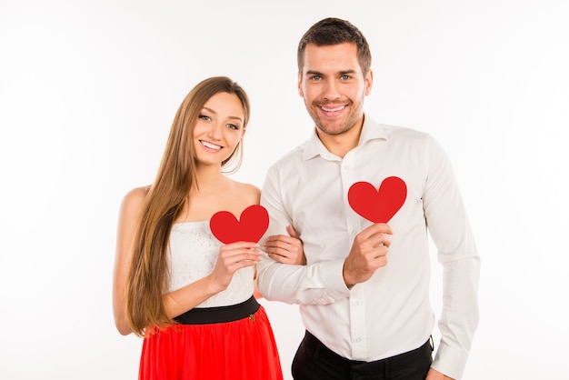 Sonriente pareja enamorada de corazones de papel