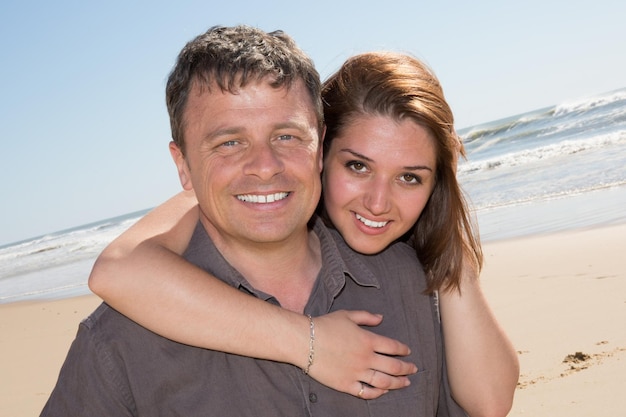 Sonriente pareja enamorada en la playa coqueteando