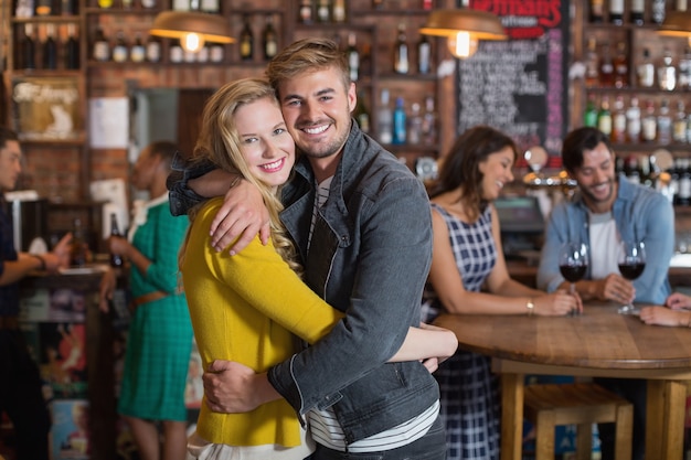 Sonriente, pareja joven, abrazar, en, pub