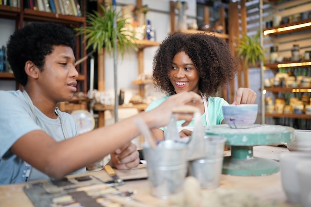 Sonriente pareja joven en taller de cerámica