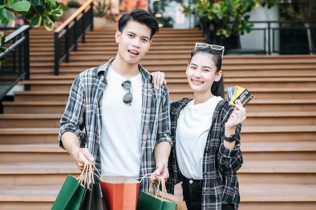 Sonriente, pareja joven, tenencia, múltiple, papel, bolsa de compras