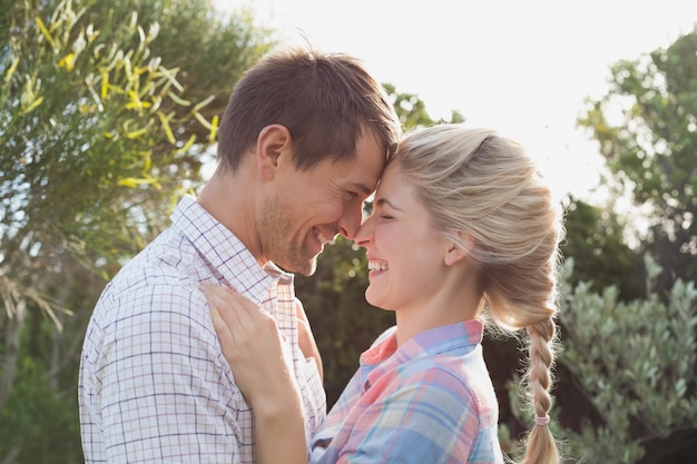 Sonriente pareja mirándose contra el cielo