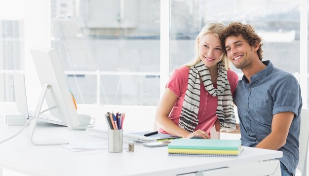 Sonriente pareja de negocios informal en una oficina brillante