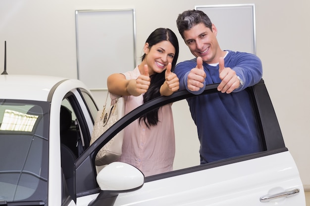 Foto sonriente, pareja, posición, mientras, dar, pulgares arriba