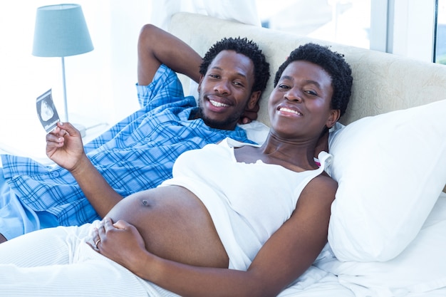 Sonriente pareja relajada acostada en la cama