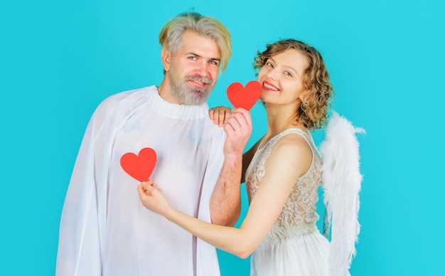 Sonriente pareja de san valentín con corazones de papel ángeles con alas blancas relaciones de amor