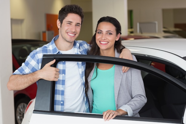 Sonriente pareja en una tienda de coches