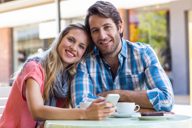 Sonriente pareja tomando un té en un café