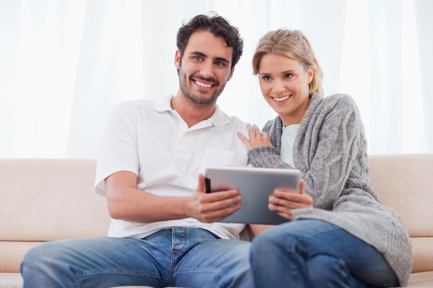 Sonriente pareja usando una tableta