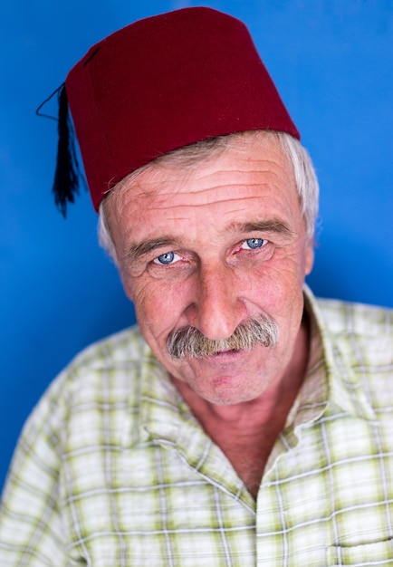 Sonriente y seguro hombre maduro con bigote, arrugas y cabello gris