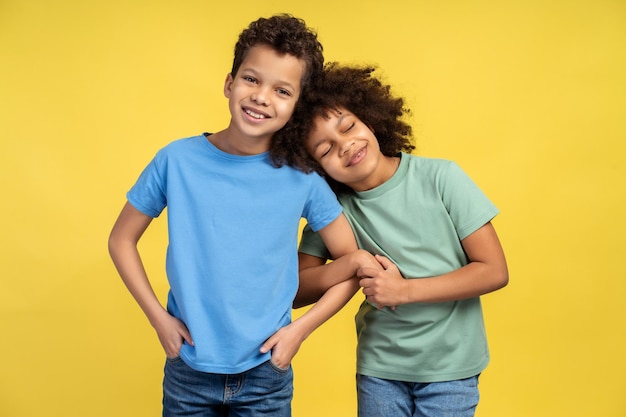 Foto sonrientes niños afroamericanos hermano y hermana lindos con ropa elegante y colorida abrazándose