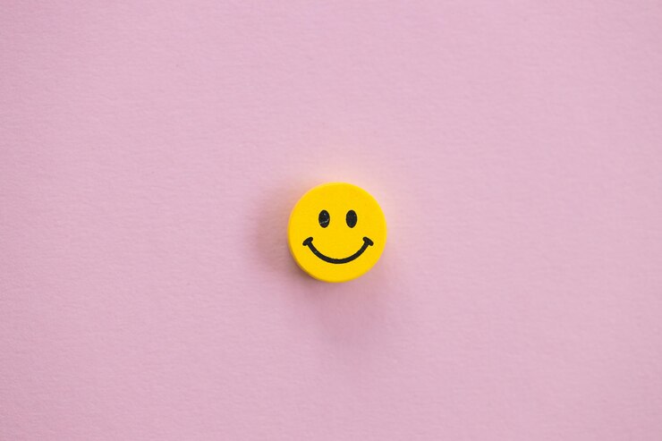 Sonrisa amarilla sobre fondo rosa