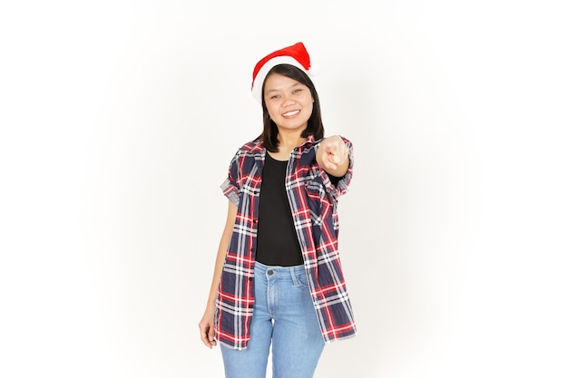 Sonrisa y apuntando a usted de hermosa mujer asiática vestida con camisa a cuadros roja y gorro de Papá Noel