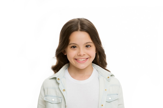 Sonrisa brillante. Niño encantador sonrisa blanca aislado fondo blanco. Niño niña pelo largo y rizado alegre feliz. Cara sonriente adorable del peinado rizado de la muchacha. Niño feliz sin preocupaciones disfruta de la infancia.