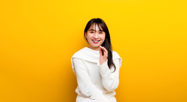 Sonrisa brillante Retrato de una bella empresaria asiática de pie y sonriendo por separado. sobre un fondo amarillo