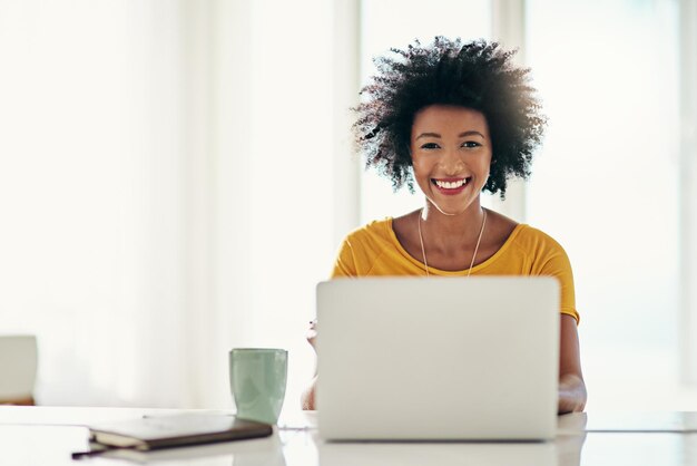 Sonrisa de computadora portátil y en línea con retrato de mujer negra para planificar sitio web y trabajador remoto Redes de blogs y redes sociales con mujer independiente en casa para tecnología de correo electrónico e Internet