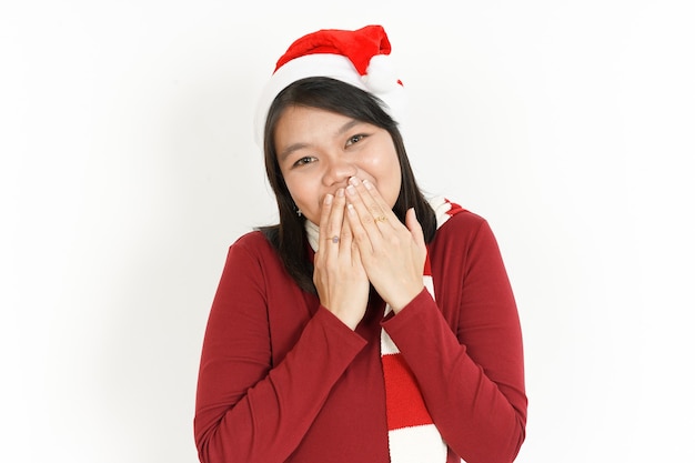 Sonrisa y cubriendo la boca de la hermosa mujer asiática vestida con cuello alto rojo y gorro de Papá Noel
