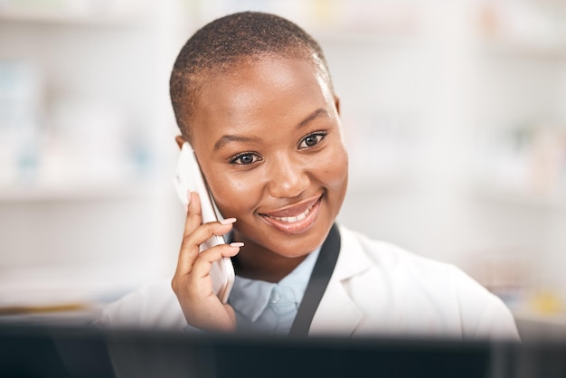 Sonrisa de farmacia y mujer hablando por teléfono mientras lee información Persona africana o farmacéutico en un teléfono inteligente para consultas de telesalud o servicio al cliente y asesoramiento sobre atención médica