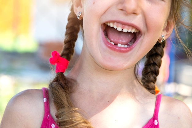 Sonrisa feliz sin dientes de una niña con un diente de leche inferior caído primer plano Cambio de dientes a molares en la infancia