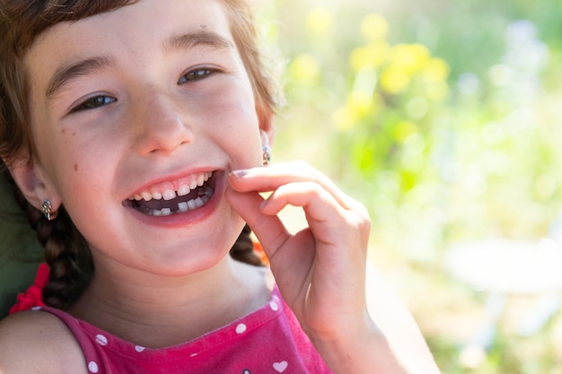 Sonrisa feliz sin dientes de una niña con un diente de leche inferior caído primer plano Cambio de dientes a molares en la infancia