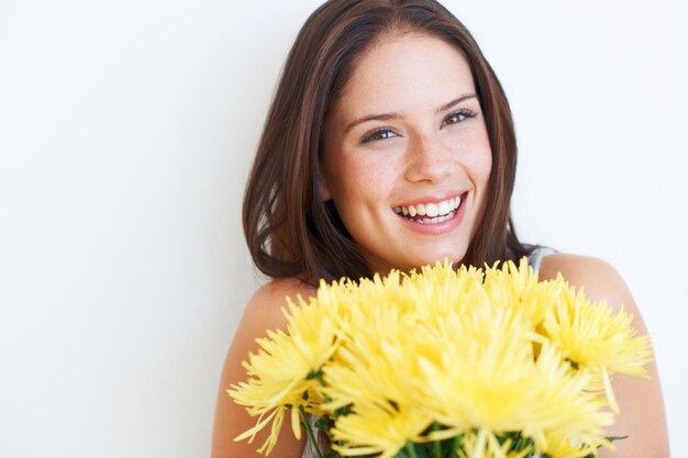 Sonrisa feliz y flores con retrato de mujer y maqueta para celebración de primavera y regalo Verano floral y belleza con niña y ramo aislado sobre fondo blanco para fecha presente y evento