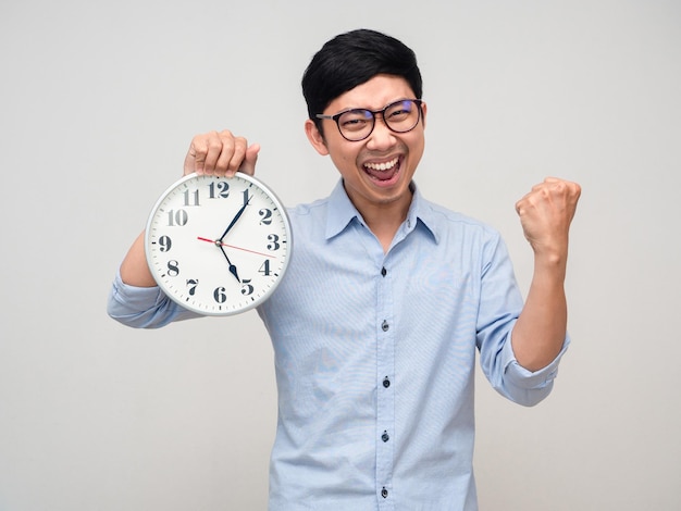 Sonrisa feliz de hombre de negocios asiático con reloj analógico muestra el puño para el éxito aislado