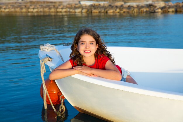 Foto sonrisa feliz de la muchacha del niño del marinero relajada en arco del barco