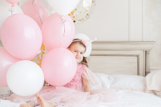 Sonrisa feliz niña con tacones desnudos sostiene paquetes de globos cumpleaños de niños copia espacio simulacro