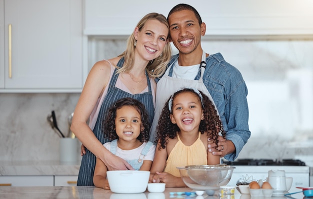 Sonrisa feliz y retrato de una familia en la cocina cocinando juntos para una cena de fiesta o evento Felicidad amor y padres interraciales uniéndose y horneando con sus hijos en su hogar moderno