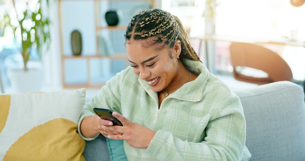 Sonrisa hogareña y mujer con un teléfono celular a Internet y conexión con redes sociales, mecanografía y red Persona apartamento y niña con un usuario móvil de teléfono inteligente y contacto con aplicación digital y relajación