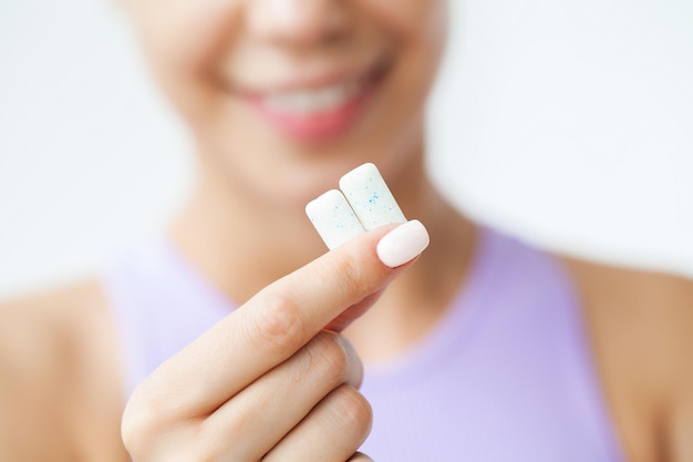 Sonrisa joven comiendo chicle blanco