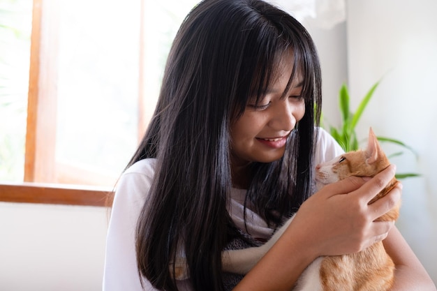 Sonrisa joven con un gato en casa