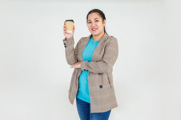 Sonrisa de mujer asiática joven y feliz de mostrar beber una taza de café para refrescarse la salud y la dieta para el ocio relajarse en ropa informal. Bebida de belleza como alimento complementario para la mujer.