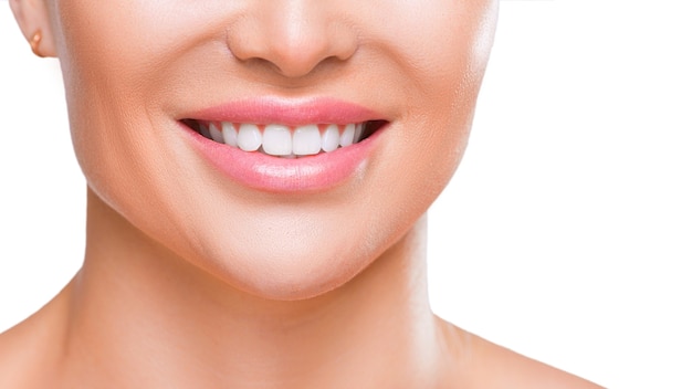 Sonrisa de mujer con dientes blancos sanos vista cercana aislado sobre fondo blanco.