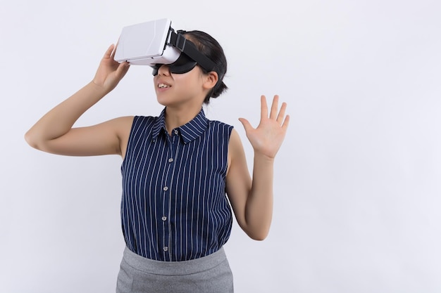 Sonrisa mujer feliz obteniendo experiencia usando gafas de auriculares VR de realidad virtual en casa mucho gesticulando manos modelo chino asiático de raza mixta