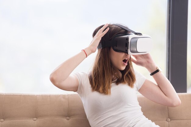 Sonrisa a mujer feliz obteniendo experiencia usando gafas de realidad virtual en casa