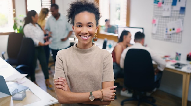 Sonrisa de mujer y retrato de diseñador con los brazos cruzados en el lugar de trabajo de oficina para negocios Confianza facial y diseño gráfico persona femenina y empresaria creativa profesional o mentalidad de éxito