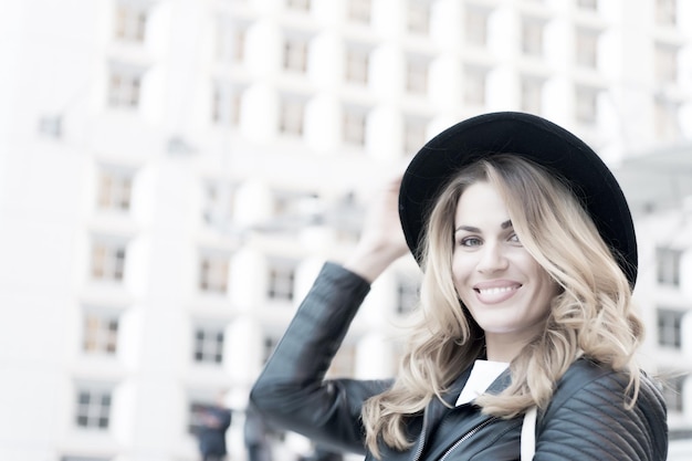 Sonrisa de mujer con rostro sensual, cabello largo, sombrero negro en la defensa, parís. Moda, belleza, mirada. Vacaciones, viajes, pasión por los viajes.