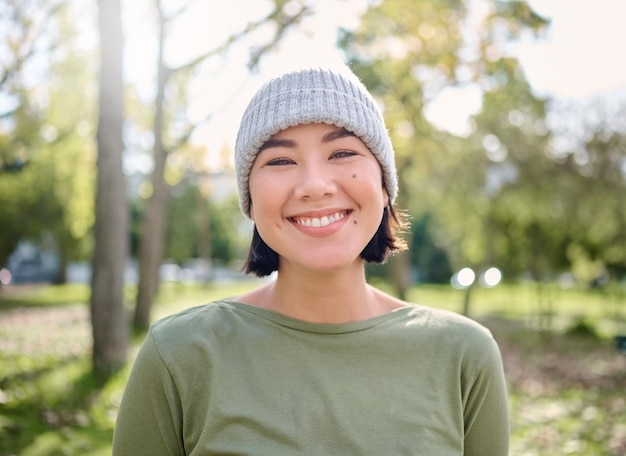 Sonrisa de la naturaleza y retrato de mujer asiática en el bosque para la libertad de aventura y caminatas para hacer ejercicio Bienestar relajarse y cara de niña disfrutando del aire fresco, paz y bosques para hacer ejercicio cardiovascular y caminar