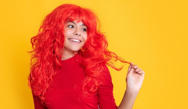 Foto sonrisa de niño adolescente con pelo largo rojo sobre fondo amarillo