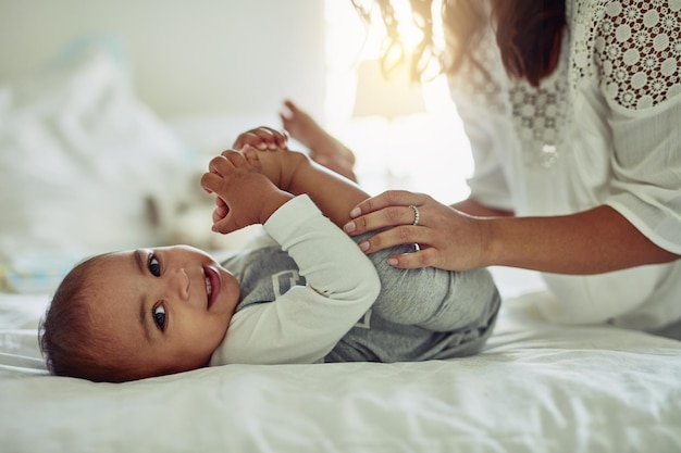 La sonrisa de un niño es la vista más preciada Fotografía de una madre irreconocible y su adorable bebé jugando juntos en casa