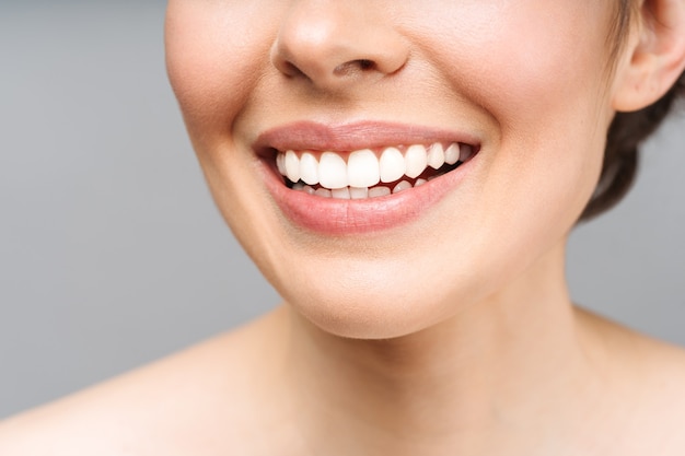 La sonrisa perfecta de los dientes sanos de una mujer joven que blanquea los dientes simboliza la imagen del paciente de la clínica dental