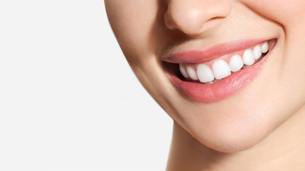 La sonrisa perfecta de los dientes sanos de una mujer joven que blanquea los dientes simboliza la imagen del paciente de la clínica dental