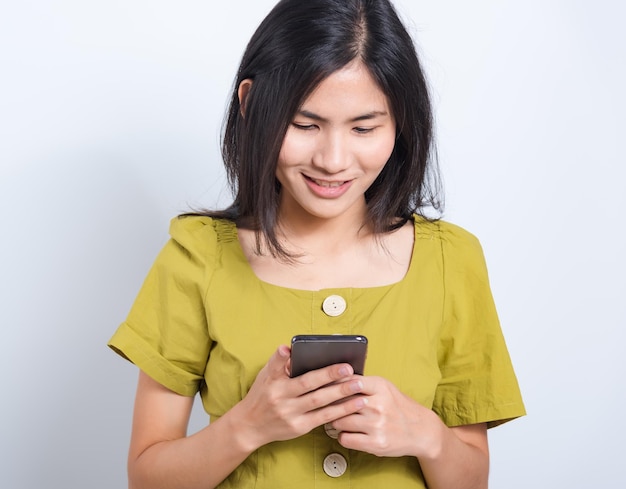 Sonrisa permanente de mujer joven sosteniendo mediante teléfono móvil inteligente