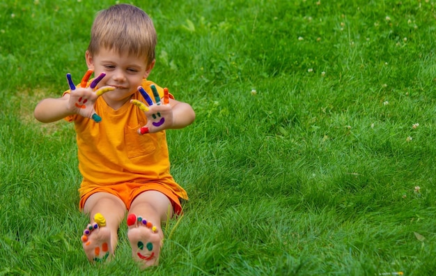 Una sonrisa pintada con pinturas en los brazos y piernas del niño.