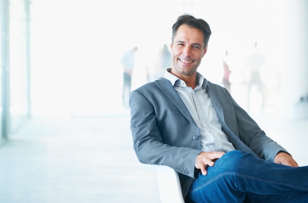 Sonrisa de retrato y hombre de negocios en la silla en la oficina con orgullo por su carrera o trabajo en maqueta Empresario profesional y feliz director ejecutivo maduro o persona de Canadá sentado en el lugar de trabajo