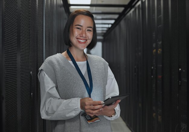 Sonrisa de retrato de mujer asiática y técnico con tableta en la sala de servidores para mantenimiento de redes o inspección del sistema Ingeniera feliz sonriendo con pantalla táctil en gestión de datos o monitoreo